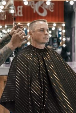 BARBER STRONG - The Barber Cape - Black With 24k Gold Pinstripe -Care Product Shop BSC10 BLK GOLD Black Gold Stripes Barber Cape Lifestyle 3 1800x1800 12206.1600240585