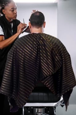 BARBER STRONG - The Barber Cape - Black With 24k Gold Pinstripe -Care Product Shop BSC10 BLK GOLD Black Gold Stripes Barber Cape Lifestyle 4 1800x1800 53295.1600240585